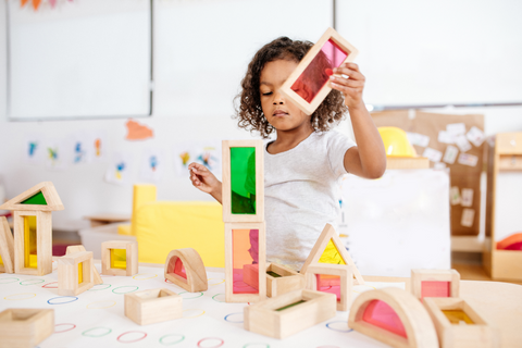 child in classroom playing with building blocks